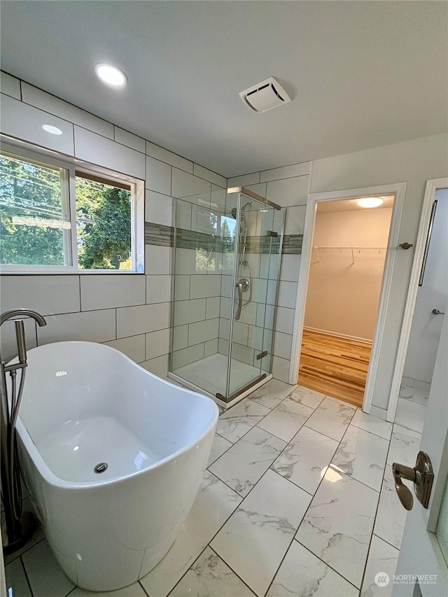 bathroom featuring independent shower and bath