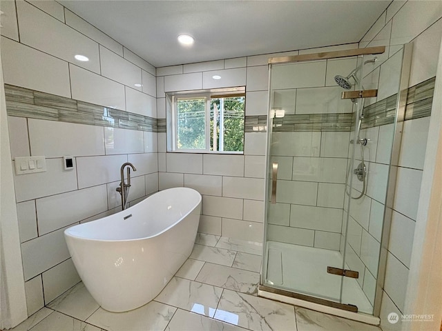 bathroom with tile walls and independent shower and bath