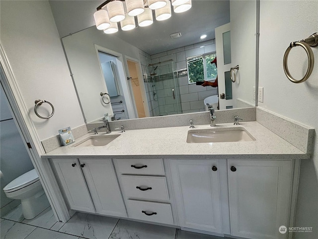 bathroom featuring a shower with door, vanity, and toilet