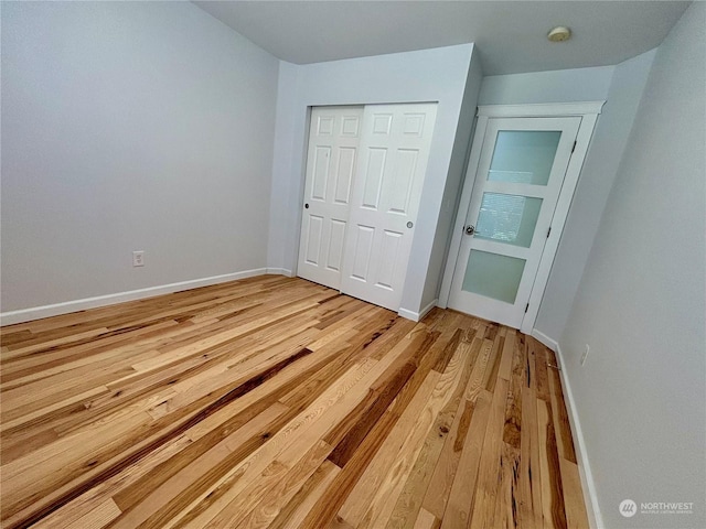 unfurnished bedroom with light hardwood / wood-style flooring and a closet