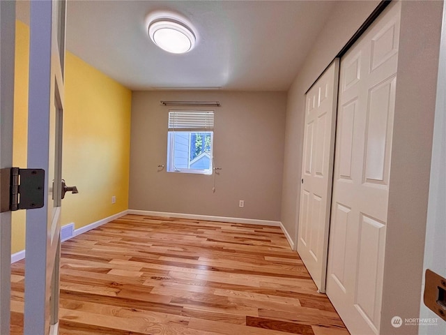 unfurnished bedroom with a closet and light hardwood / wood-style flooring