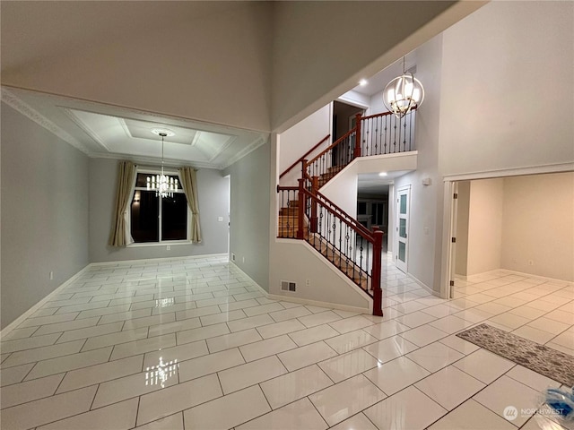 entryway with light tile patterned floors, crown molding, a high ceiling, and a notable chandelier