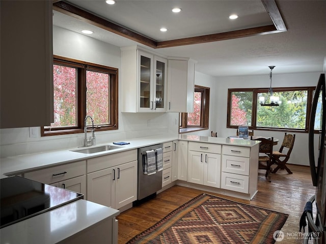 3917 Mallard Point Dr, Anacortes, WA 98221 - kitchen featuring a peninsula, stainless steel dishwasher, a sink, dark wood finished floors, and white cabinetry