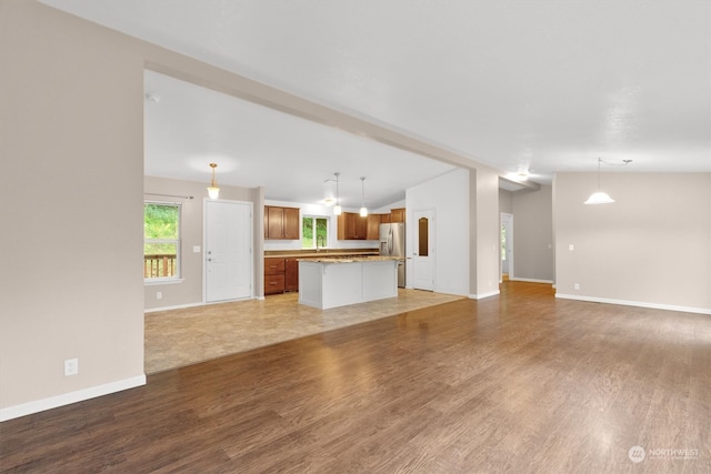 unfurnished living room featuring hardwood / wood-style flooring and lofted ceiling