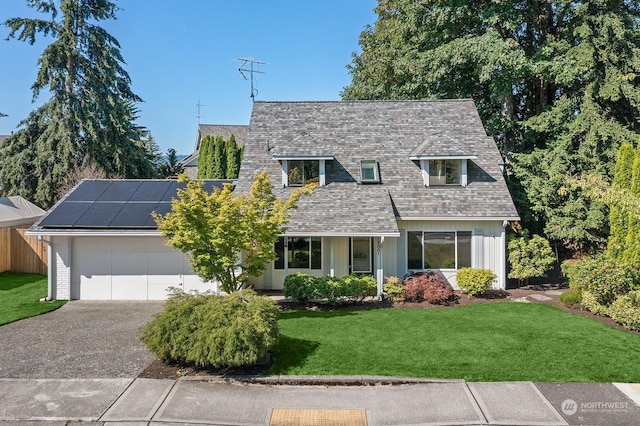 cape cod home with a front lawn and solar panels