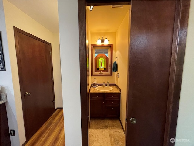 hallway with baseboards and a sink