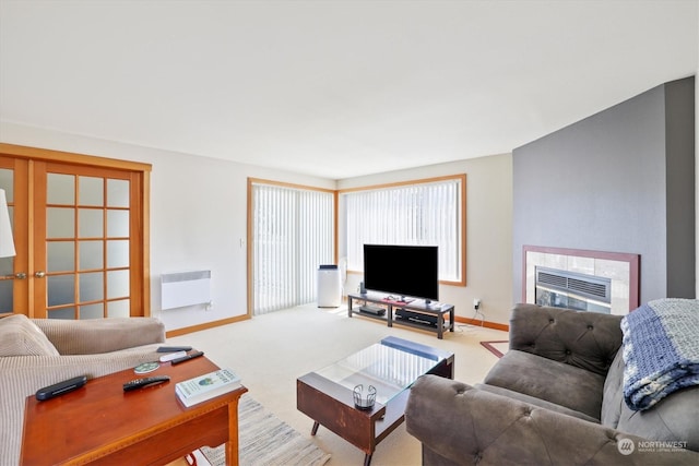 living room featuring heating unit, radiator heating unit, light colored carpet, and a fireplace