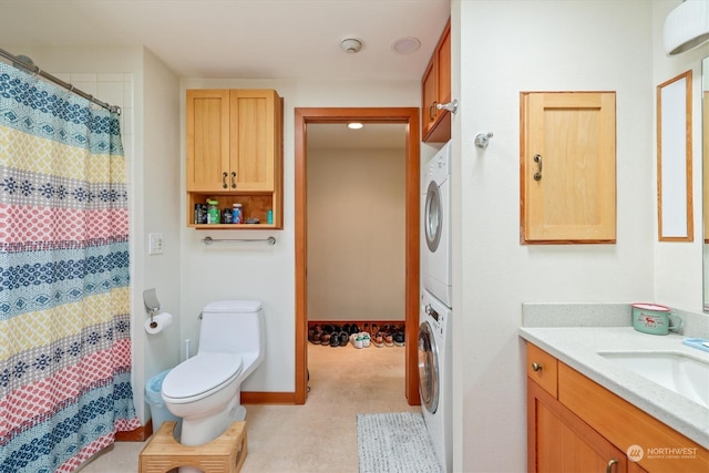 bathroom featuring toilet, stacked washing maching and dryer, and vanity