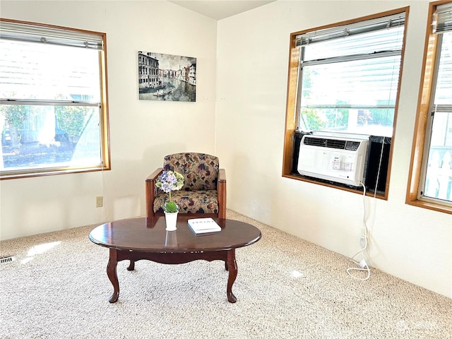 sitting room featuring cooling unit, a healthy amount of sunlight, and carpet