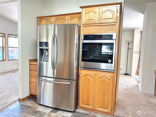 kitchen with appliances with stainless steel finishes and dark carpet