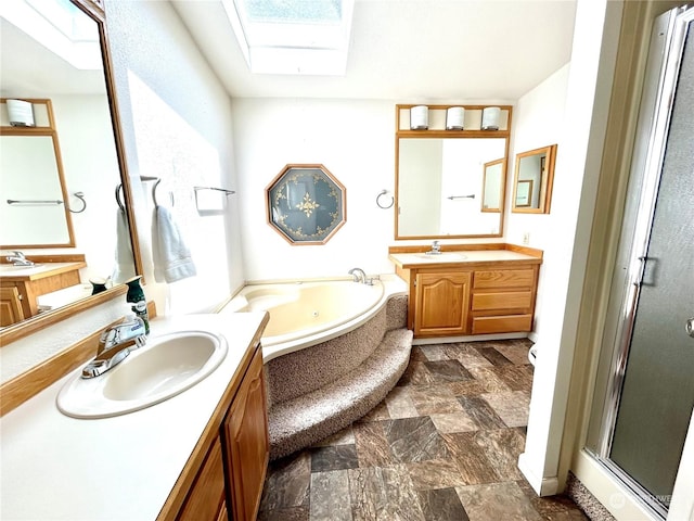 bathroom with vanity, a skylight, and separate shower and tub