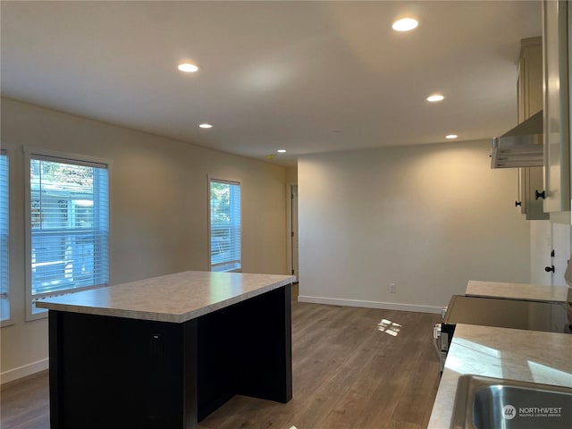 kitchen with a center island, plenty of natural light, dark wood-type flooring, and range hood