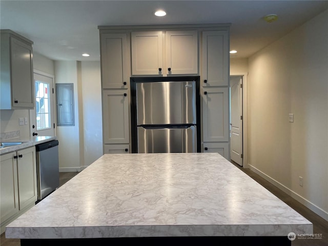 kitchen featuring gray cabinets, a kitchen island, dark hardwood / wood-style floors, and appliances with stainless steel finishes