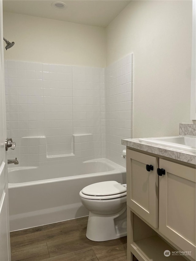 full bathroom with hardwood / wood-style floors, vanity, toilet, and shower / tub combination