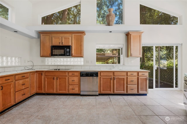 kitchen with black appliances, a wealth of natural light, and a high ceiling