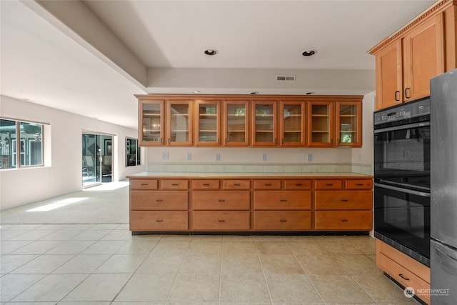 kitchen with fridge, light tile patterned floors, and double oven