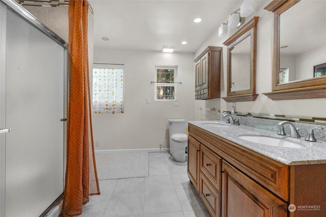 bathroom with double vanity, tile patterned floors, and toilet