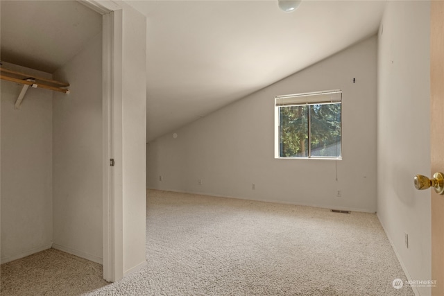 additional living space featuring carpet floors and vaulted ceiling