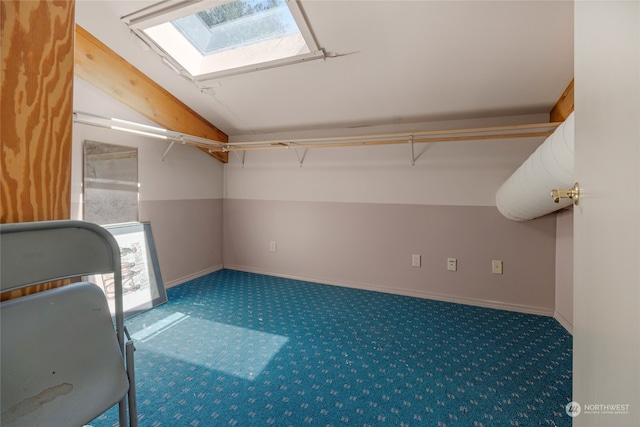 interior space featuring carpet flooring and vaulted ceiling with skylight