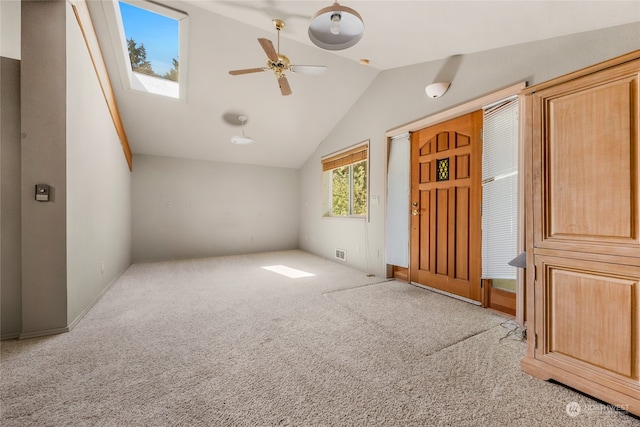 interior space featuring light carpet and vaulted ceiling with skylight