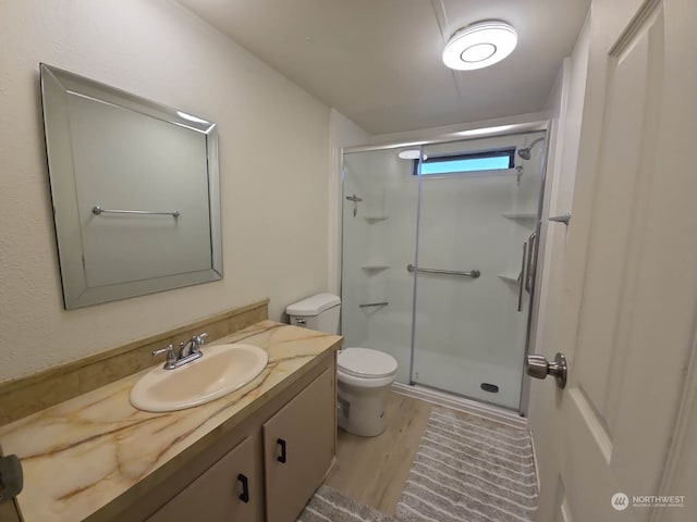 bathroom featuring vanity, hardwood / wood-style flooring, toilet, and walk in shower