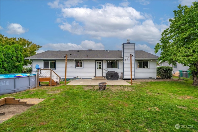 rear view of property featuring a lawn and a patio