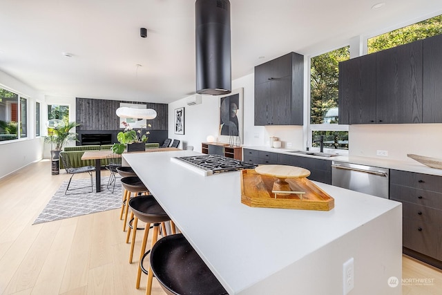 kitchen featuring a kitchen island, appliances with stainless steel finishes, sink, and a breakfast bar