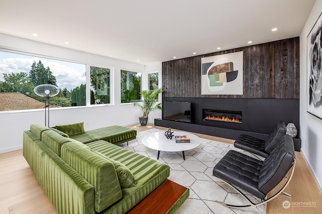 living room with a large fireplace and light hardwood / wood-style flooring