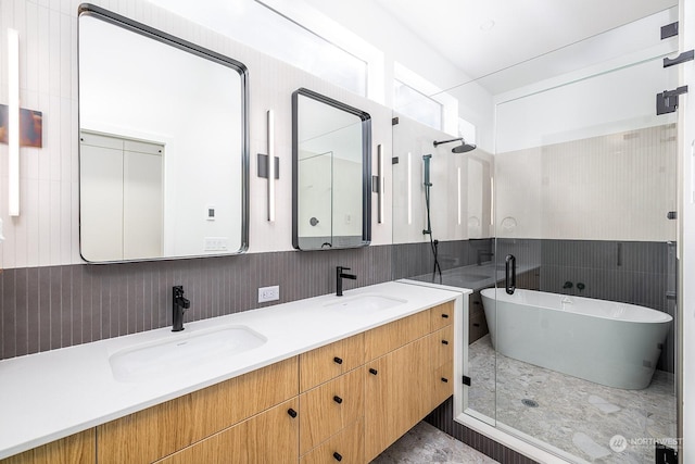 bathroom featuring vanity, shower with separate bathtub, and tile walls