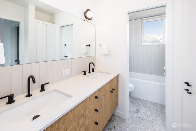 bathroom with vanity, toilet, and decorative backsplash