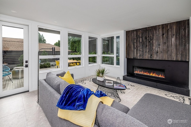 living room with a large fireplace and light tile patterned floors