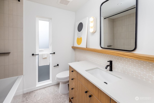 bathroom with vanity, toilet, and decorative backsplash