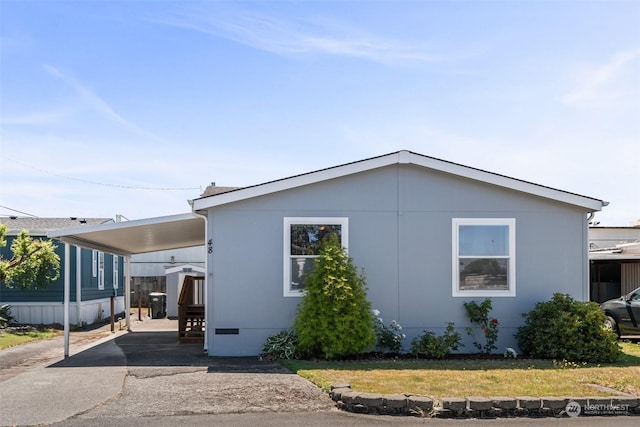 view of side of property with a carport and a lawn