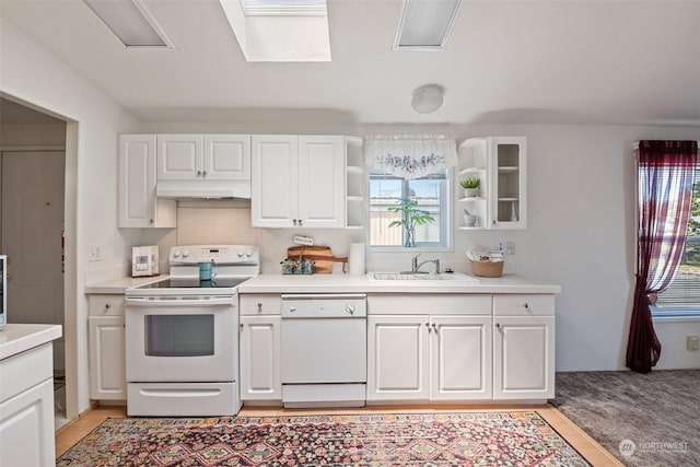 kitchen featuring light countertops, white cabinetry, a sink, white appliances, and under cabinet range hood