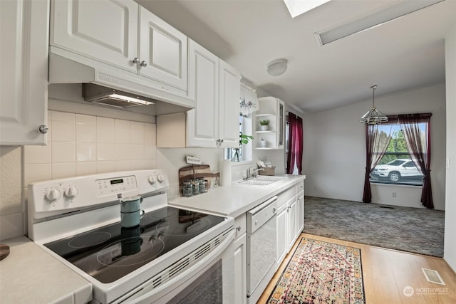 kitchen featuring light countertops, white appliances, hanging light fixtures, and white cabinetry