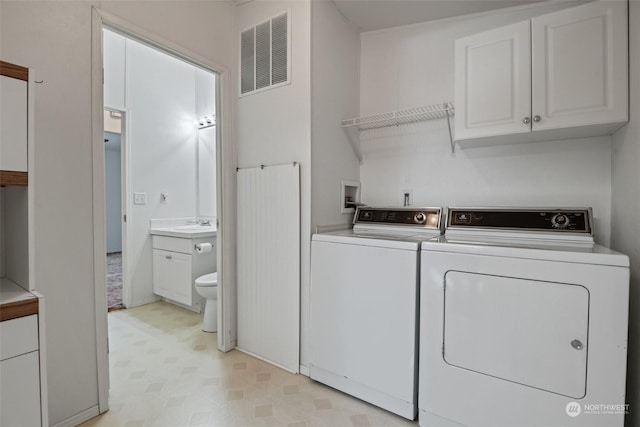 washroom with cabinet space, visible vents, light floors, separate washer and dryer, and a sink