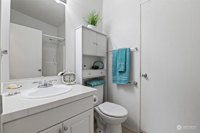 full bath featuring toilet, a shower, and vanity