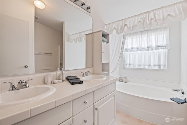 full bath with a bath, double vanity, visible vents, and a sink