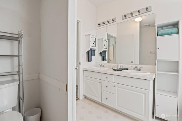 full bathroom featuring tile patterned floors, a sink, toilet, and double vanity