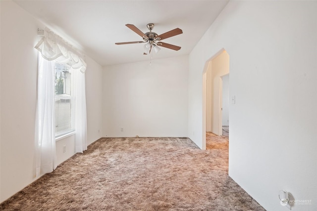 spare room with ceiling fan and light colored carpet