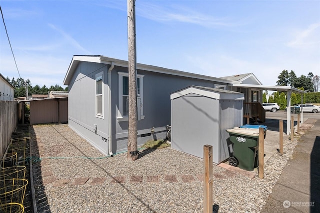 view of property exterior featuring a carport, crawl space, and fence