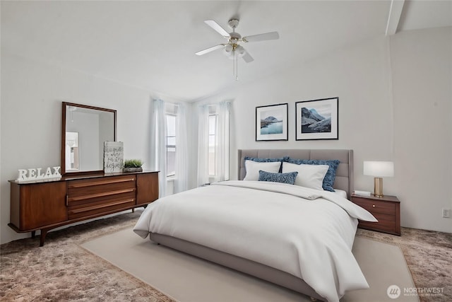 bedroom with light carpet, vaulted ceiling, and a ceiling fan