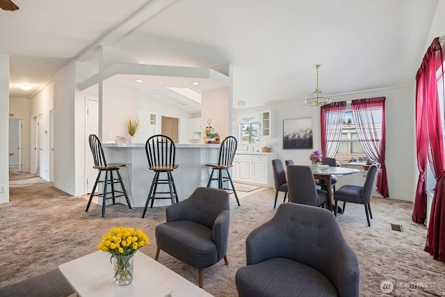 living area featuring vaulted ceiling, visible vents, and light colored carpet