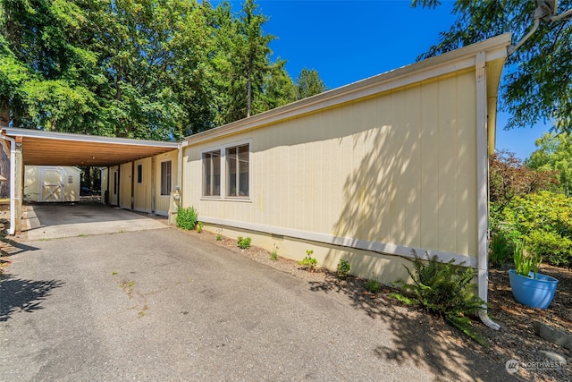 view of home's exterior featuring a carport and aphalt driveway