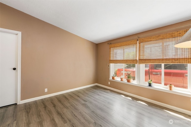 spare room with wood finished floors and baseboards