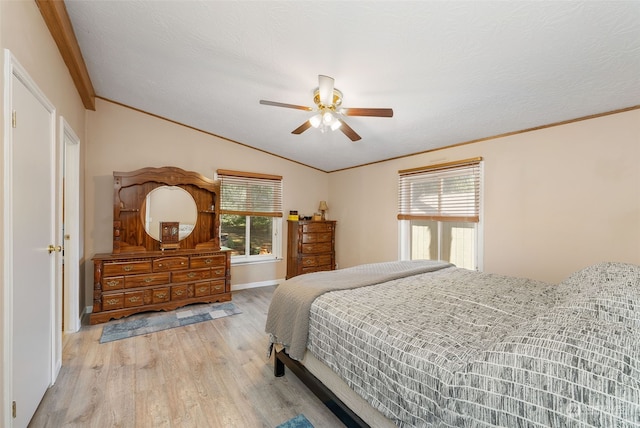 bedroom featuring ceiling fan, a textured ceiling, wood finished floors, vaulted ceiling, and ornamental molding