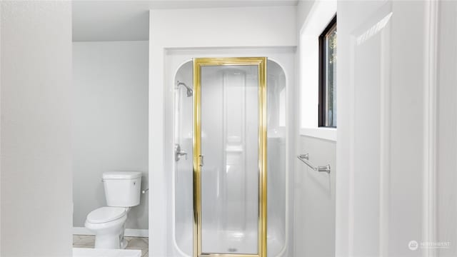 bathroom with a shower with shower door, tile patterned floors, and toilet