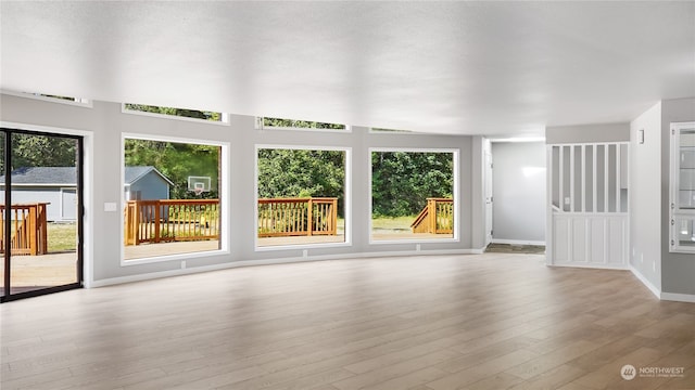 unfurnished living room with light wood-type flooring and plenty of natural light