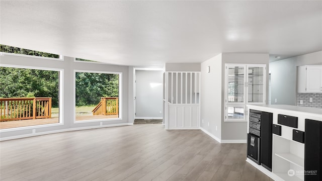 unfurnished living room featuring light hardwood / wood-style flooring and a healthy amount of sunlight