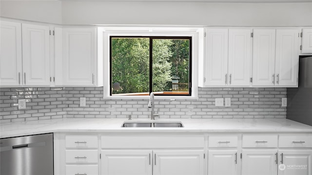 kitchen with sink, stainless steel dishwasher, white cabinetry, and tasteful backsplash